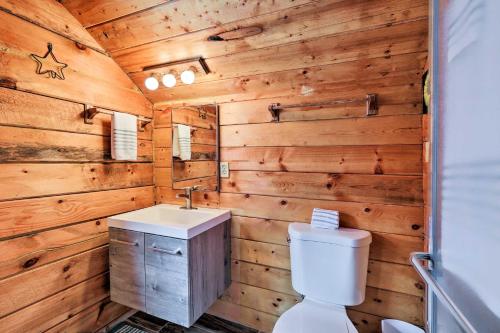 a bathroom with wooden walls and a toilet and a sink at Furnished Deck Cabin in Coconino National Forest in Munds Park