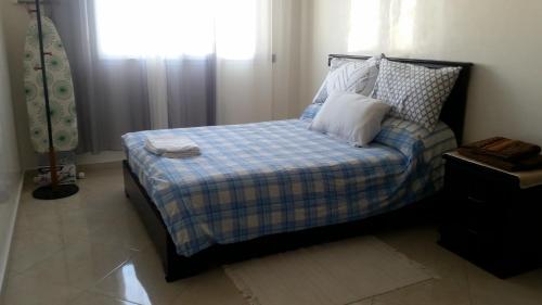 een slaapkamer met een bed met kussens en een raam bij Appart au Centre de Rabat مرحبا in Rabat