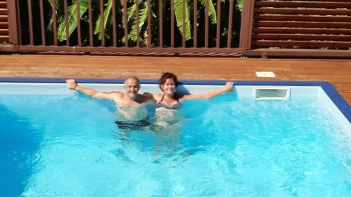 Ein Mann und eine Frau im Schwimmbad. in der Unterkunft Lili bungalows in Capesterre