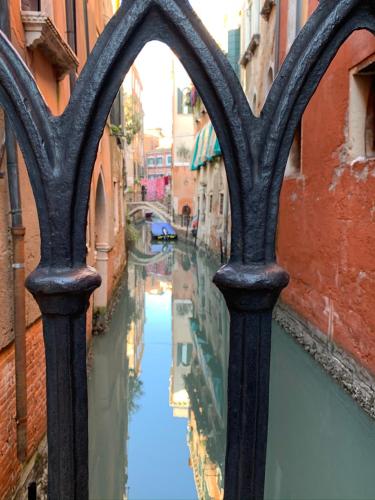 a view of a canal through a wrought iron fence at ROOFTOP TERRACE Domus dei fabbri in Venice