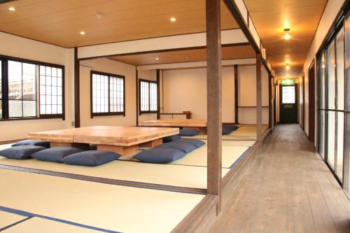 an empty room with a table and blue pillows at 淡路島西海岸の宿 梅木屋 in Sumoto