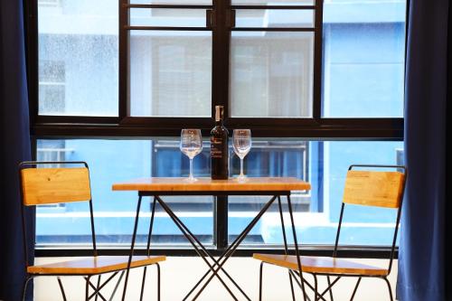 a table with two glasses and a bottle of wine at 130 Hotel & Residence Bangkok in Bangkok