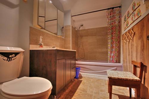 a bathroom with a toilet and a sink and a tub at Vieille Maison Rustique Espace Intéressant in Quebec City