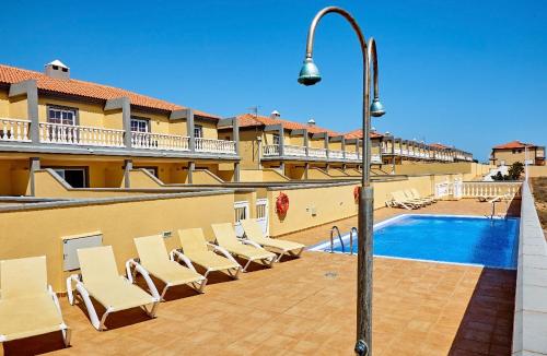 - un groupe de chaises assises à côté de la piscine dans l'établissement Medano Beach Villas, à El Médano