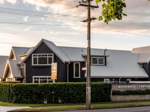 a black house with a gray roof at Matamata Central Motel in Matamata