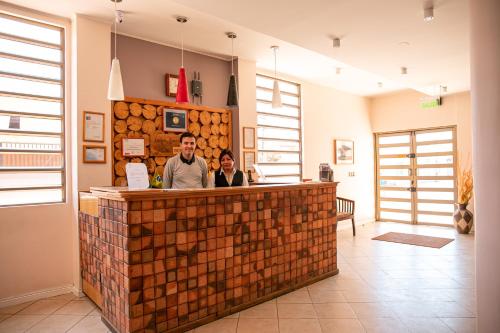 two men standing at the counter of a wood store at Ayelen Apart Hotel in Calama