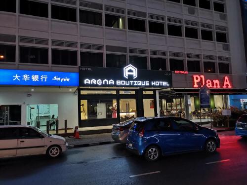 een auto die 's nachts voor een gebouw geparkeerd staat bij ARENA Boutique Hotel Kuala Terengganu in Kuala Terengganu