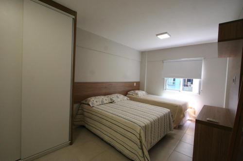 Habitación de hotel con 2 camas y espejo en Apartamento NOVO Beira Mar JTR, en Maceió