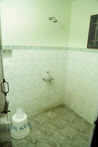 a bathroom with a shower with a toilet in it at ZuriEL Suite GUEST HOUSE in Coimbatore