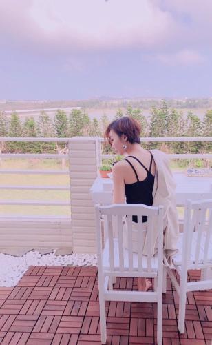 a woman sitting in a chair on a balcony at Happiness Factory in Huxi
