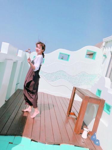a woman standing on top of a wooden deck at Happiness Factory in Huxi