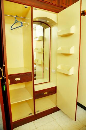 a walk in closet with a mirror and shelves at ZuriEL Suite GUEST HOUSE in Coimbatore