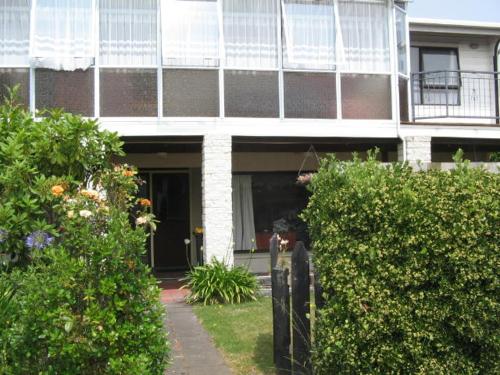 una casa con un porche y una valla delante de ella en The House, en Christchurch