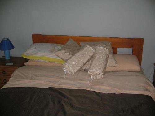 una cama con almohadas encima en The House, en Christchurch