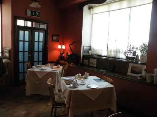 a dining room with two tables and a window at Buggle's Pub and Accommodation in Kilrush