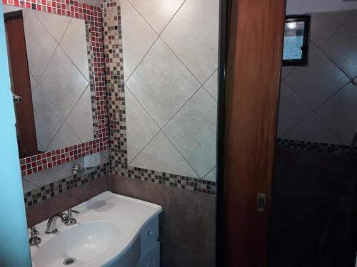 W łazience znajduje się umywalka i lustro. w obiekcie Ariel Reynoso - Departamento Planta Baja w mieście Mina Clavero