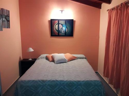 1 dormitorio con 1 cama y una foto en la pared en Ariel Reynoso - Departamento Planta Baja en Mina Clavero
