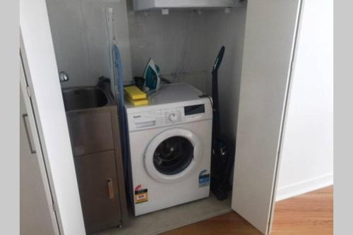 a washing machine in a small room with a sink at Lvl 57 Skytower Breathtaking Views CBD Wifi Carpark by Stylish Stays in Brisbane