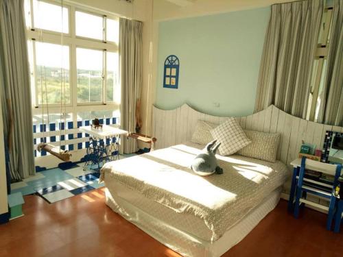 a bedroom with a bed with a stuffed animal on it at Happiness Factory in Huxi