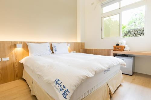 sypialnia z dużym białym łóżkiem i oknem w obiekcie Blue Lagoon w mieście Huxi