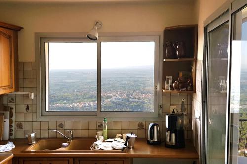 une cuisine avec une fenêtre donnant sur un évier. dans l'établissement Villa Josephine: Vue magnifique sur mer et montagnes, à Laroque-des-Albères