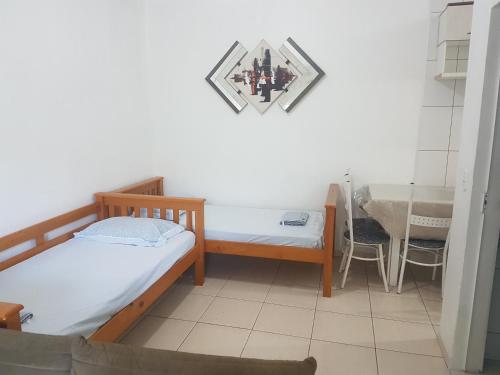 a room with two beds and a table and a sink at Apartamento exclusivo-hospedagem in Joinville