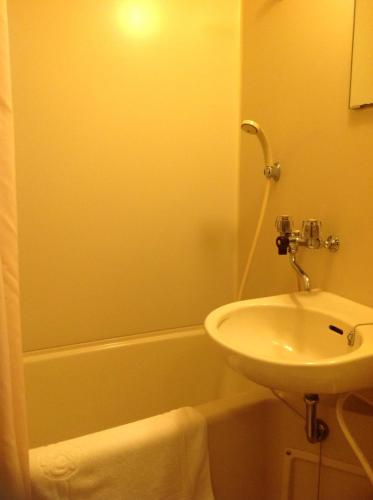 Un baño con lavabo, inodoro y bañera. en Jyonai Hotel, en Karatsu