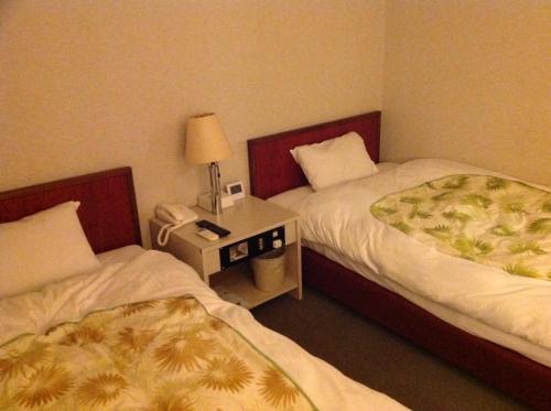 מיטה או מיטות בחדר ב-Jonai Hotel