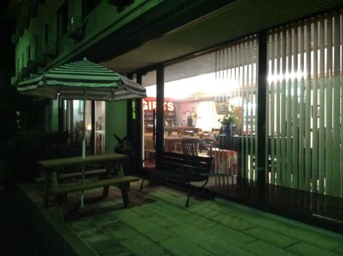 a patio with a bench and an umbrella at night at Jonai Hotel in Karatsu