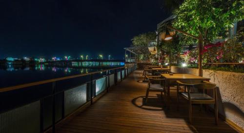 a row of tables and chairs on a balcony at night at The B Resort in Kampot