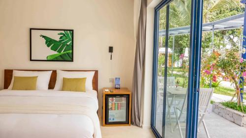 a bedroom with a bed and a sliding glass door at The B Resort in Kampot