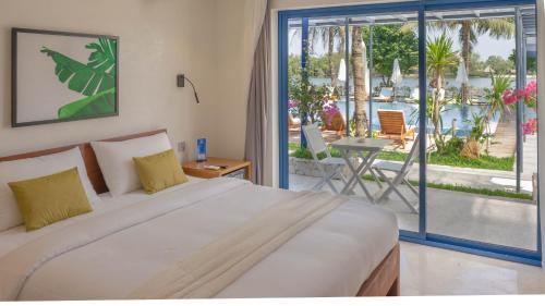 a bedroom with a bed and a view of a patio at The B Resort in Kampot
