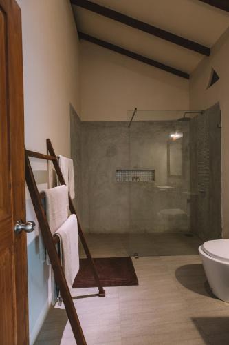 a bathroom with a shower and a sink and a toilet at Sevanagama in Habarana