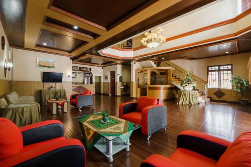 a living room with red chairs and a table at RedDoorz near RS Harapan Pematang Siantar in Pematangsiantar