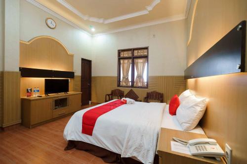 a hotel room with a bed and a telephone at RedDoorz near RS Harapan Pematang Siantar in Pematangsiantar