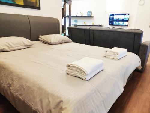 two beds with white towels on top of them at Parkview KLCC by Salaam Suites, 4 pax in Kuala Lumpur