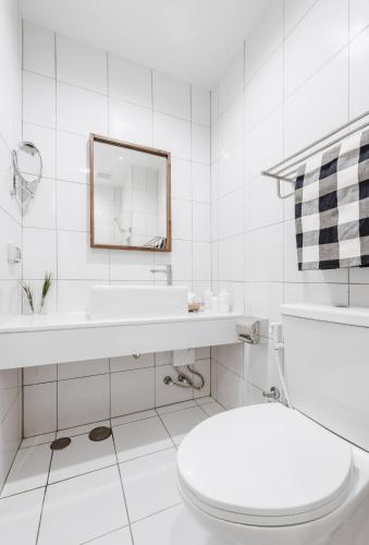 a white bathroom with a toilet and a sink at Siamplaengna Residence in Bangkok