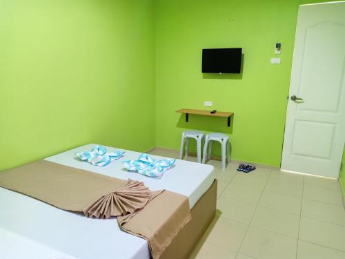 a room with two beds and a table and a television at Alona Guest House in Panglao