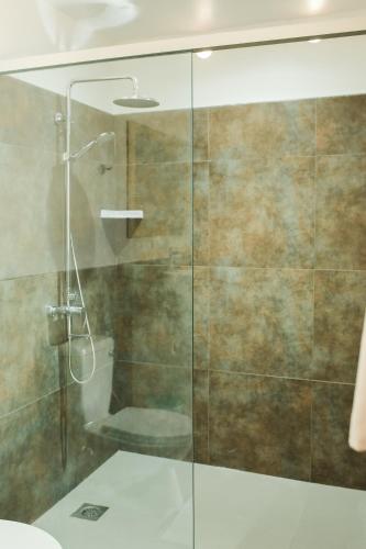 a bathroom with a glass shower with a toilet at Bali Villas Panglao Bohol in Panglao