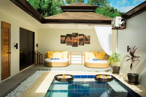 a patio with a table and chairs and a pool at Bali Villas Panglao Bohol in Panglao Island