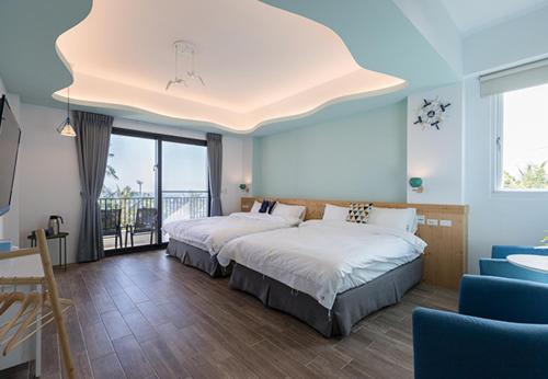 - une chambre avec 2 lits et une grande fenêtre dans l'établissement Auspice Garden Homestay, à Donghe