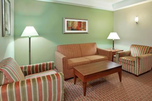 a hotel room with a couch and two chairs and a table at Holiday Inn Express & Suites Niagara Falls by IHG in Niagara Falls