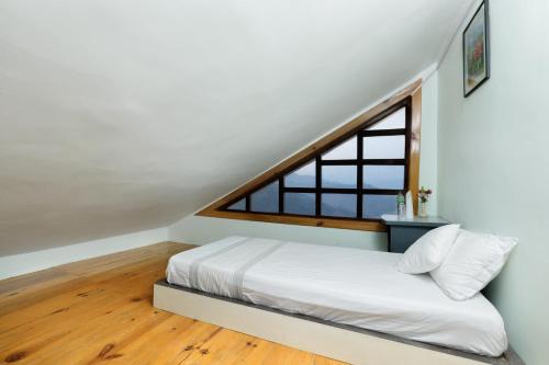 a bedroom with a bed and a window at The Lapsi Tree in Nagarkot