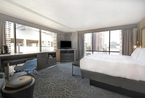 a bedroom with a bed and a desk and a television at Holiday Inn - Memphis Downtown - Beale St. by IHG in Memphis