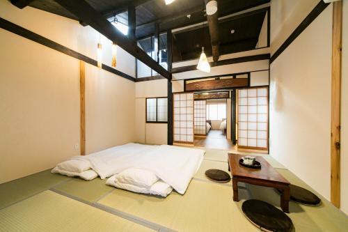 een kamer met een bed en een tafel. bij Nishodo Machiya HIKARU GOJO in Kyoto