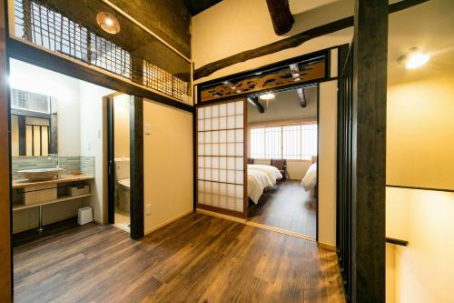 a room with a bed and a room with a mirror at Nishodo Machiya HIKARU GOJO in Kyoto