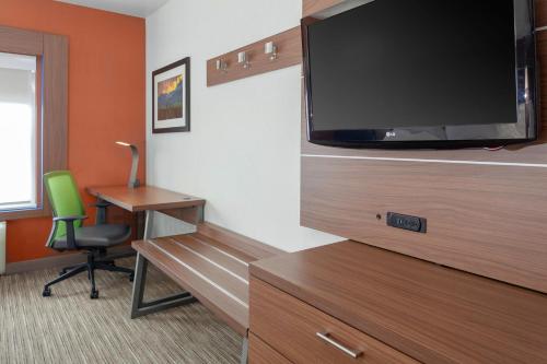 a room with a tv and a desk and a chair at Holiday Inn Express Hotel & Suites Coeur D'Alene I-90 Exit 11 by IHG in Coeur d'Alene