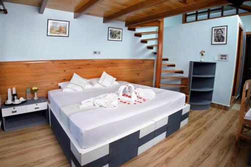 a bedroom with a large white bed with a staircase at The Lapsi Tree in Nagarkot