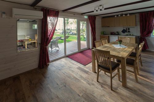 a kitchen and dining room with a wooden table and chairs at Kiviranna puhkemajad in Suure-Rakke