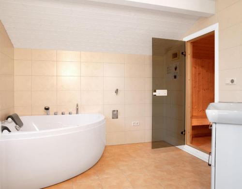 Dänische Ferienhäuser am Salzhaff Haus Pacific في إنسيل بويل: حمام مع حوض استحمام ودش ومغسلة